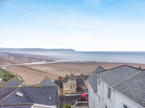 A coastal town with buildings, a beach, and a view of the sea.