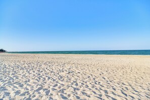 Ein Sandstrand mit Fußspuren, die zum Wasser führen.
