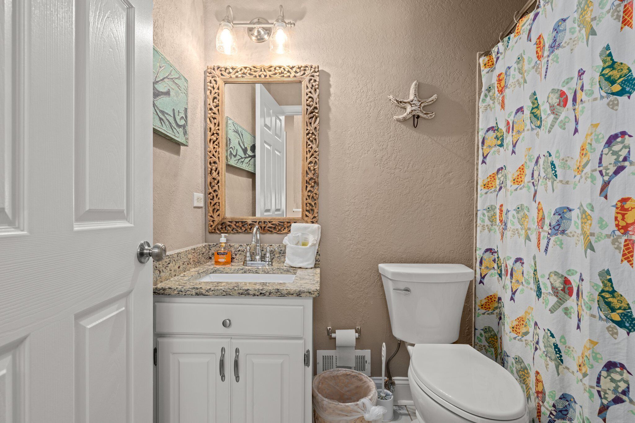 A bathroom with a sink, toilet, and shower curtain.