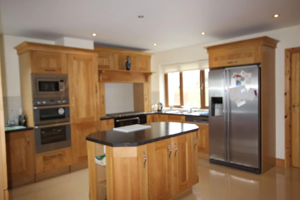 A kitchen with wooden cabinets, a stainless steel refrigerator, and built-in appliances.