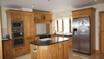 A kitchen with wooden cabinets, a stainless steel refrigerator, and built-in appliances.