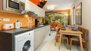 Une cuisine moderne équipée d’un lave-linge, d’un four à micro-ondes et d’une machine à café.