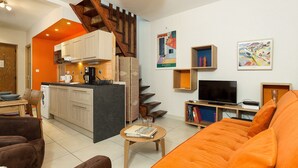 Un salon moderne avec un canapé, une table basse et un coin cuisine avec un escalier.