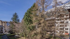 A mountain resort with multi-story buildings, a ski lift, and a clear view of snow-capped mountains. - A central, one bedroom apartment, perfect for a couple or small group. (Chamonix-Mont-Blanc)