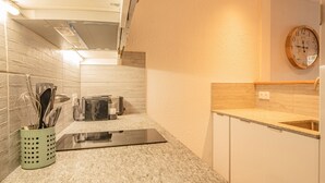 A modern kitchen with a granite countertop, stainless steel appliances, and a wooden backsplash. - A central, one bedroom apartment, perfect for a couple or small group. (Chamonix-Mont-Blanc)