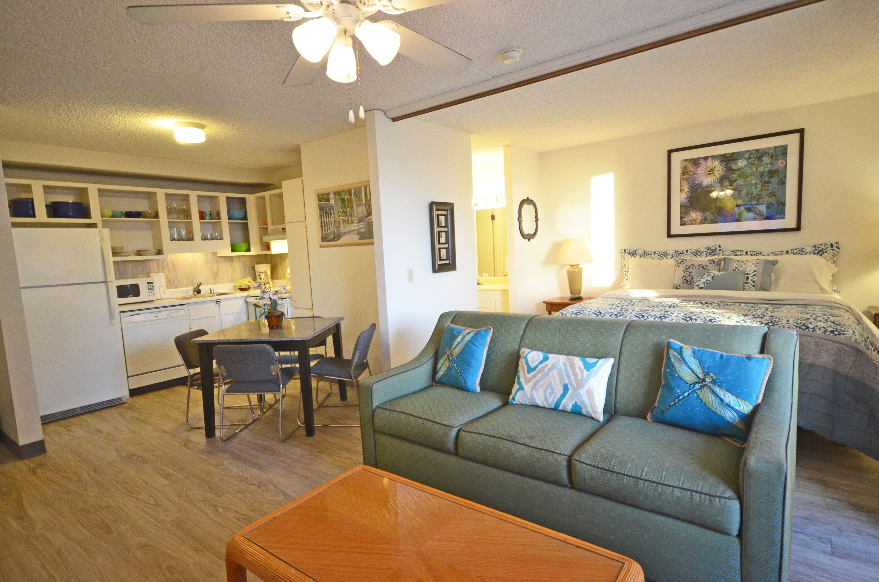 A compact living space with a kitchenette, a dining area, and a bedroom.