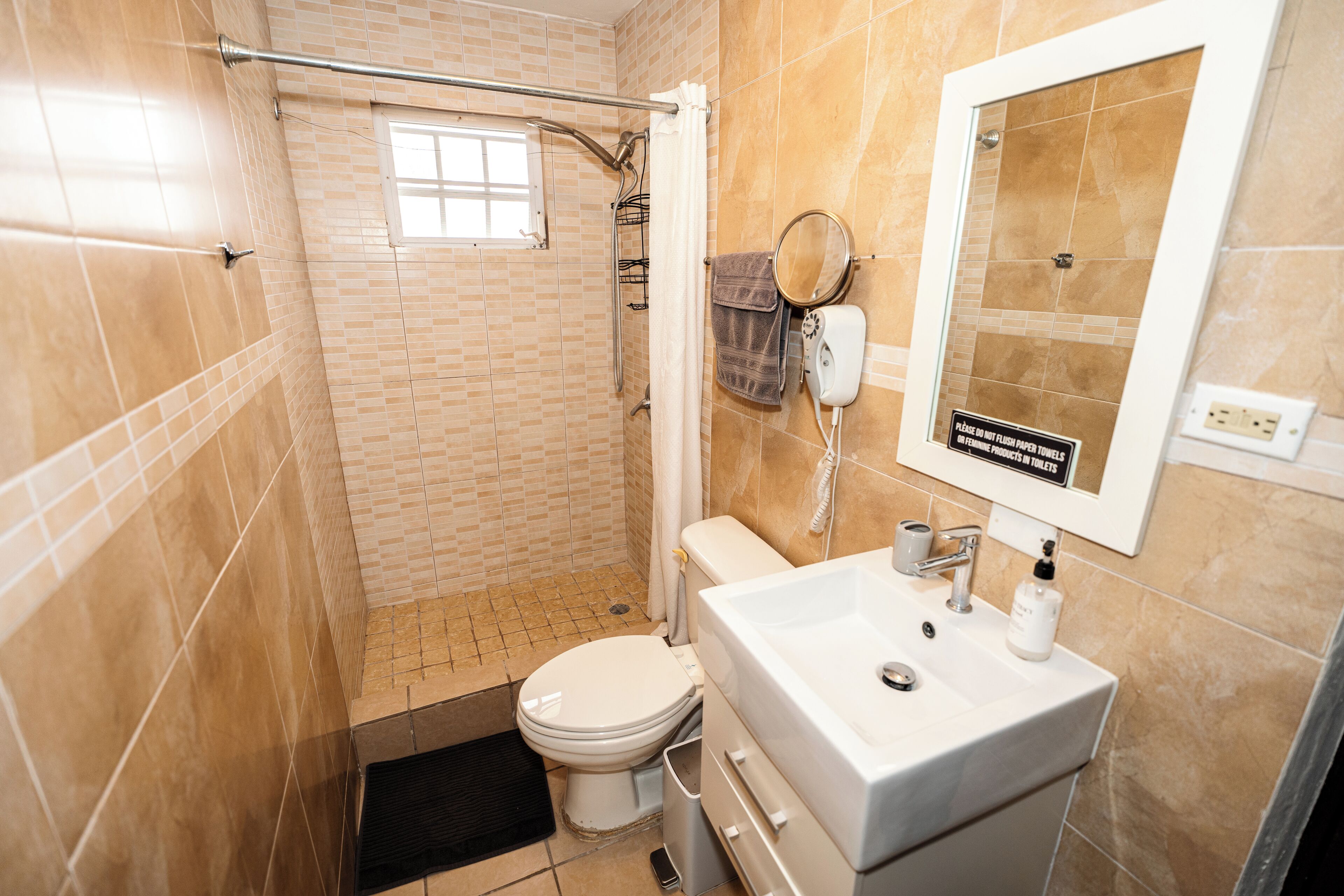 Une salle de bain comprenant des toilettes, un lavabo et un espace douche.