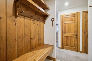 A wooden bench, a wooden door, and a wall with a keyhole.
