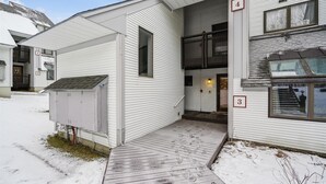 A two-story building with a covered entrance and a small porch. - Ski on/ski off, conveniently located with beautiful views, Sunrise B3 (Killington)