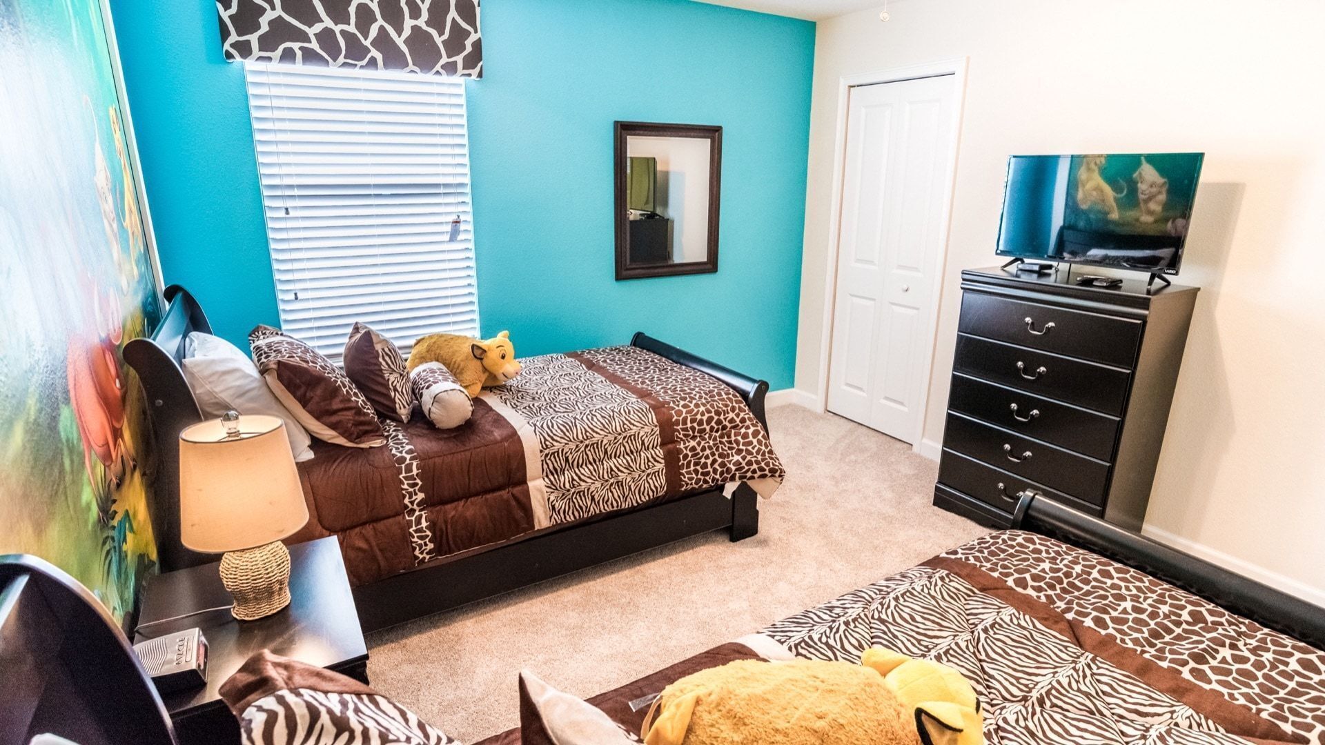 Un dormitorio con cama, cómoda, espejo y televisor.