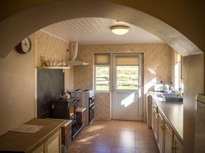A kitchen with a fireplace, a stove, and a sink. - Lough Fee, Renvyle (Renvyle)