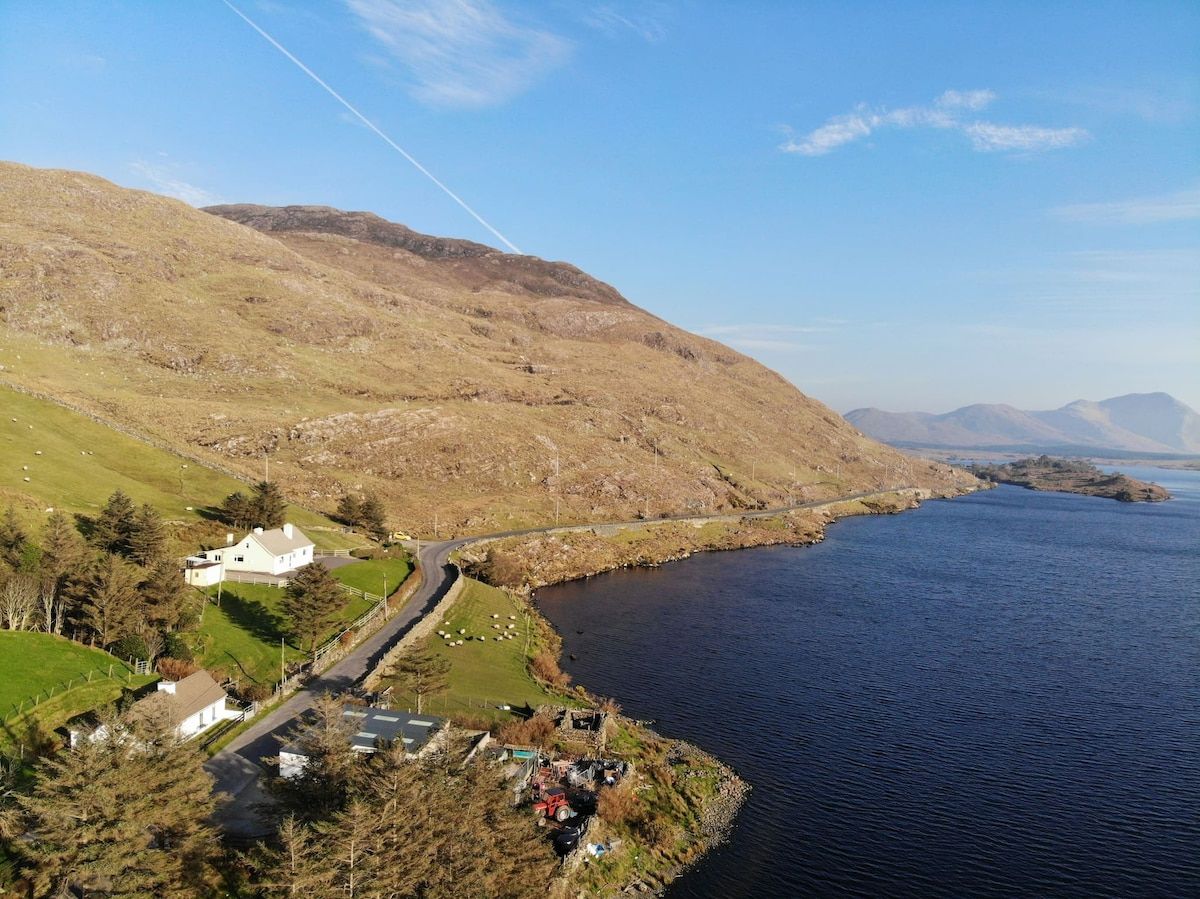 A coastal landscape with a road, a white building, and a body of water.