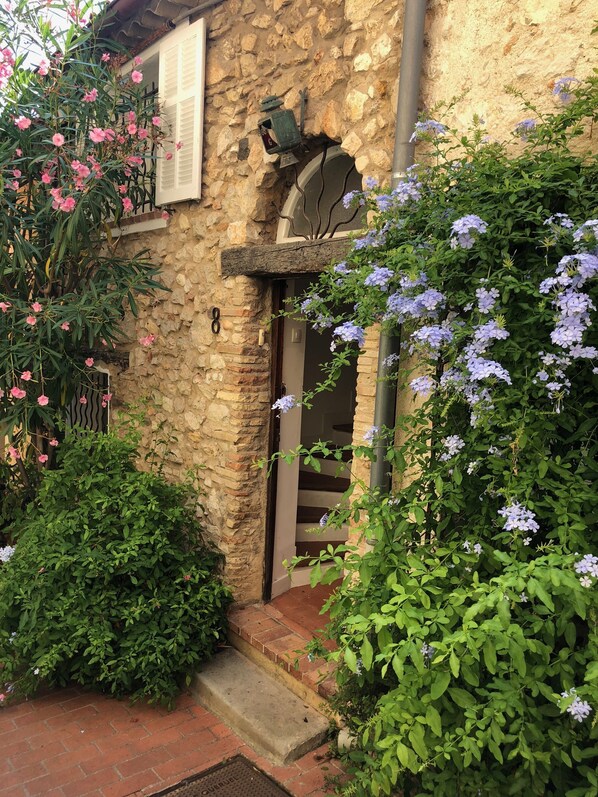 A stone building with a wooden door and a small porch.