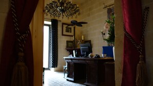 A room with a patterned floor, a desk with a computer, a chandelier, and a window with curtains. - Spacious Apartment- historical character- fascinating views over old town & sea (Valletta)