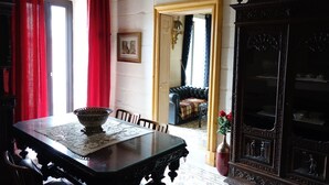 A dining area with a table, chairs, a cabinet, and a doorway leading to another room. - Spacious Apartment- historical character- fascinating views over old town & sea (Valletta)