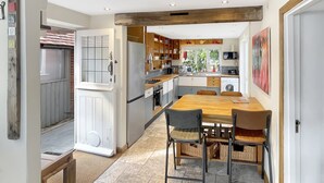Een moderne keuken met een centraal eiland, houten kastjes en uitzicht naar buiten.