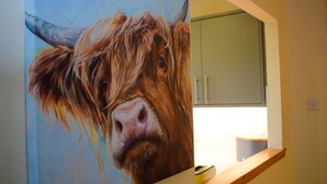 Ein Gemälde einer Kuh an einer Wand.