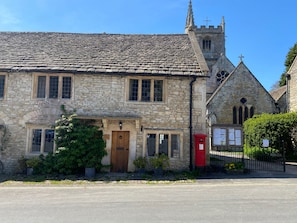 A stone building with a traditional design, featuring a prominent tower and a red post box.