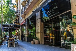 Un hotel llamado 'ALEXANDRA BARCELONA' con marca DoubleTree by Hilton, con terraza y plantas en macetas.