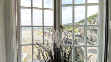 Een uitzicht op een strand en gebouwen vanuit een raam.