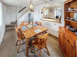 Enjoy meals in this dining area with a table for four, a buffet stand, and a staircase leading to an upper level.