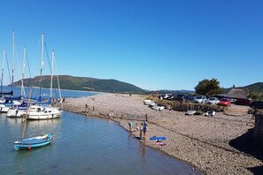 Enjoy a serene coastal scene with boats moored along the shoreline, perfect for outdoor activities.