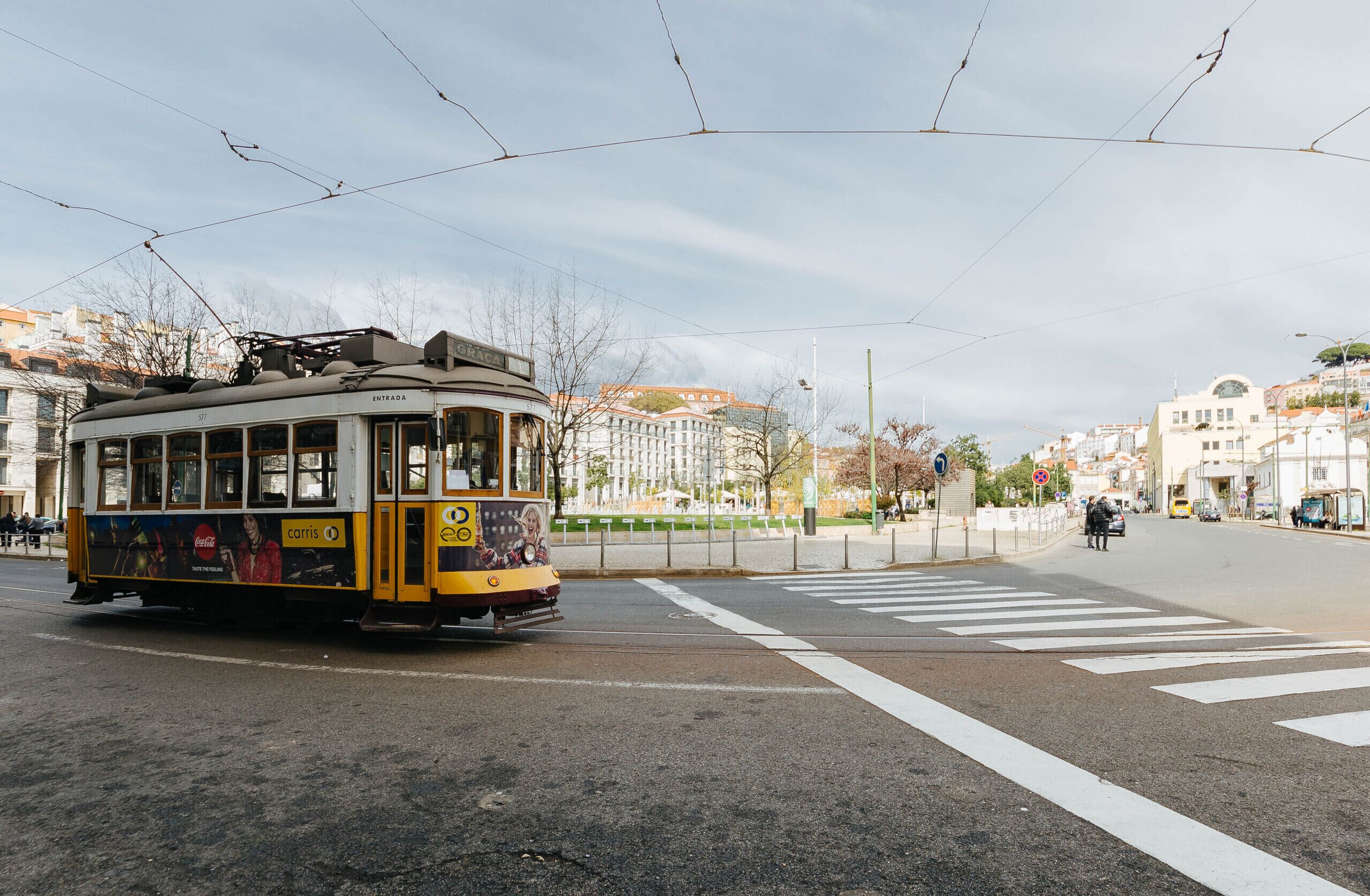 Un tramway à un carrefour, avec des bâtiments en arrière-plan.
