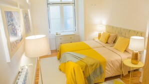 Een slaapkamer met een bed, twee nachtkastjes, een raam en een radiator.