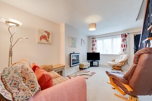 A cozy living room with a sofa, a chair, a television, and artwork on the walls. - 2 Bed in Instow (oc-n1093) (Instow)