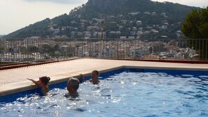 Una piscina con vista su una collina e edifici sullo sfondo.