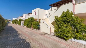 A residential street with modern houses, paved sidewalks, and well-maintained greenery. - Appartamento Oasi by BarbarHouse (Torre Pali)