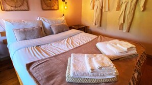 Een hotelkamer met een groot bed, twee wandlampen en twee gewanden.