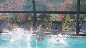 Iemand in een zwembad, omringd door opspattend water.