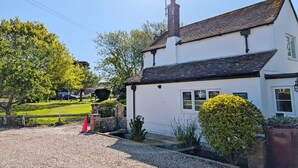 A white building with a black roof, a chimney, and a sign reading 'Springwell.' - Springwell , West Wittering -  a cottage that sleeps 4 guests  in 2 bedrooms (Chichester)