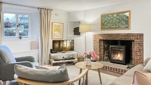 A living room with a fireplace, a television, a sofa, and a chair. - Ball Cottage, Winsford (Winsford)