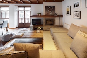 A living room with a fireplace, a television, and a sofa.