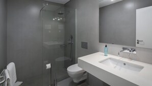 A modern bathroom with a glass-enclosed shower, a white sink, and a large mirror. - 1-bed Superior Apt B2 in character Babosas Village (Funchal)