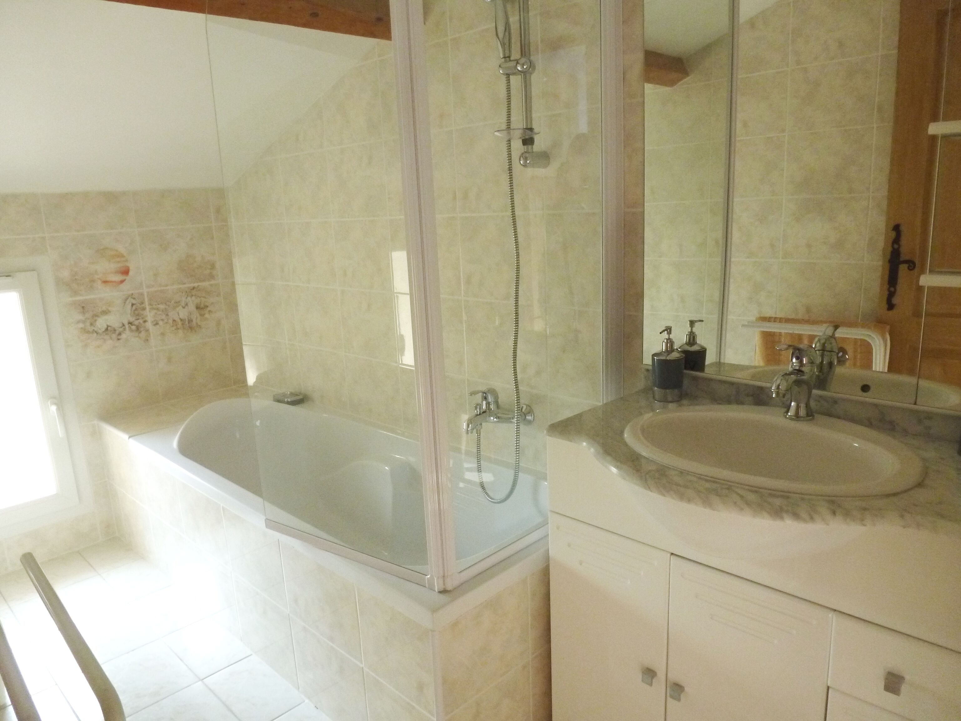 A bathroom with a bathtub, a shower, and a sink.
