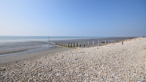 A pebbled beach with a wooden fence and a clear sky. - A family house that sleeps 6 guests  in 3 bedrooms (Chichester)