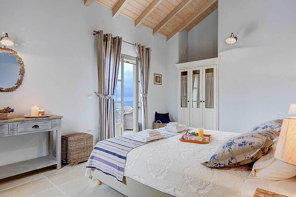 Un dormitorio con cama, cómoda, espejo y vista al exterior.