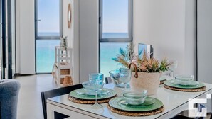 Ein Essbereich mit einem Tisch, gedeckt für zwei Personen, inklusive Gläsern und einem Blumentopf.