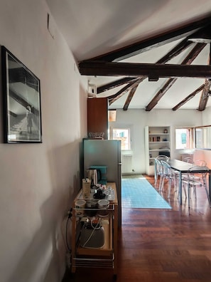 Huoneessa on puinen katto, ruokailutila tuoleineen, keittiö sekä ikkuna, josta on näkymä.