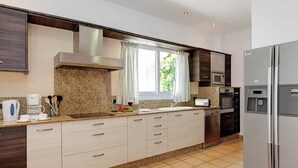 A modern kitchen with granite countertops, stainless steel appliances, and a large refrigerator.