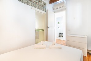 A hotel room with a bed, a wardrobe, a bathroom visible through an open door, and an air conditioning unit on the wall. - VILLA OASIS TERRA BLANCA (Palma de Mallorca)