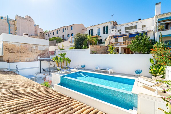 A rooftop swimming pool with lounge chairs and a view of surrounding buildings. - VILLA OASIS TERRA BLANCA (Palma de Mallorca)