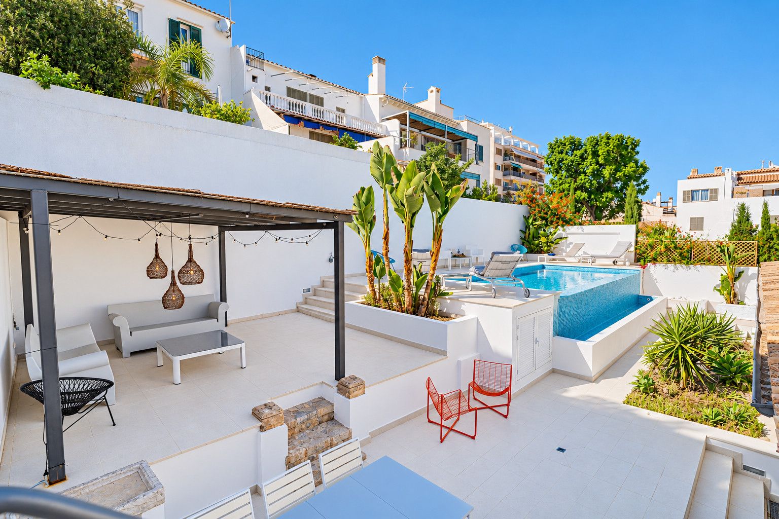 A rooftop terrace with a swimming pool, outdoor seating, and a covered area with hanging lights.