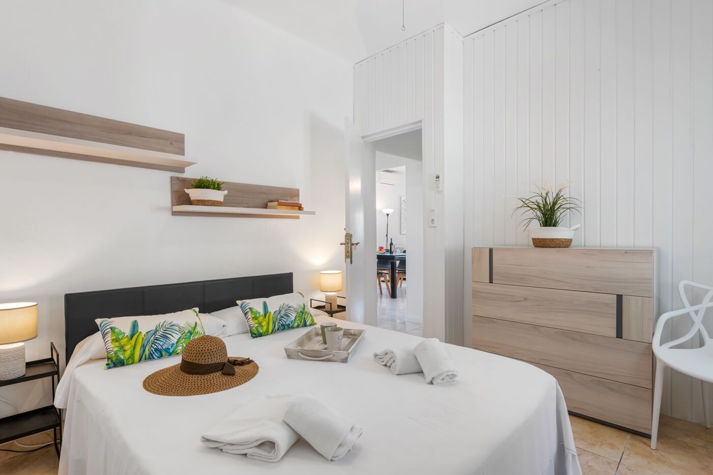 Une chambre d’hôtel avec un lit, une table de chevet, une lampe et une vue sur le couloir.