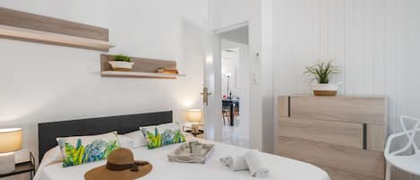 Une chambre d’hôtel avec un lit, une table de chevet, une lampe et une vue sur le couloir.