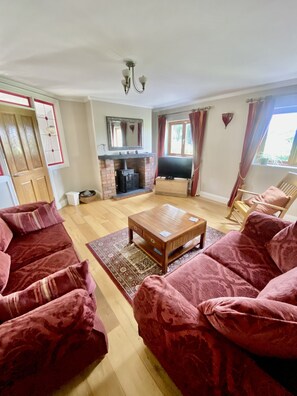 A living room with a fireplace, a television, and a sofa set.