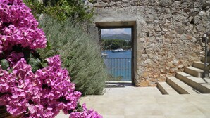 A stone building with a view of a body of water and boats.